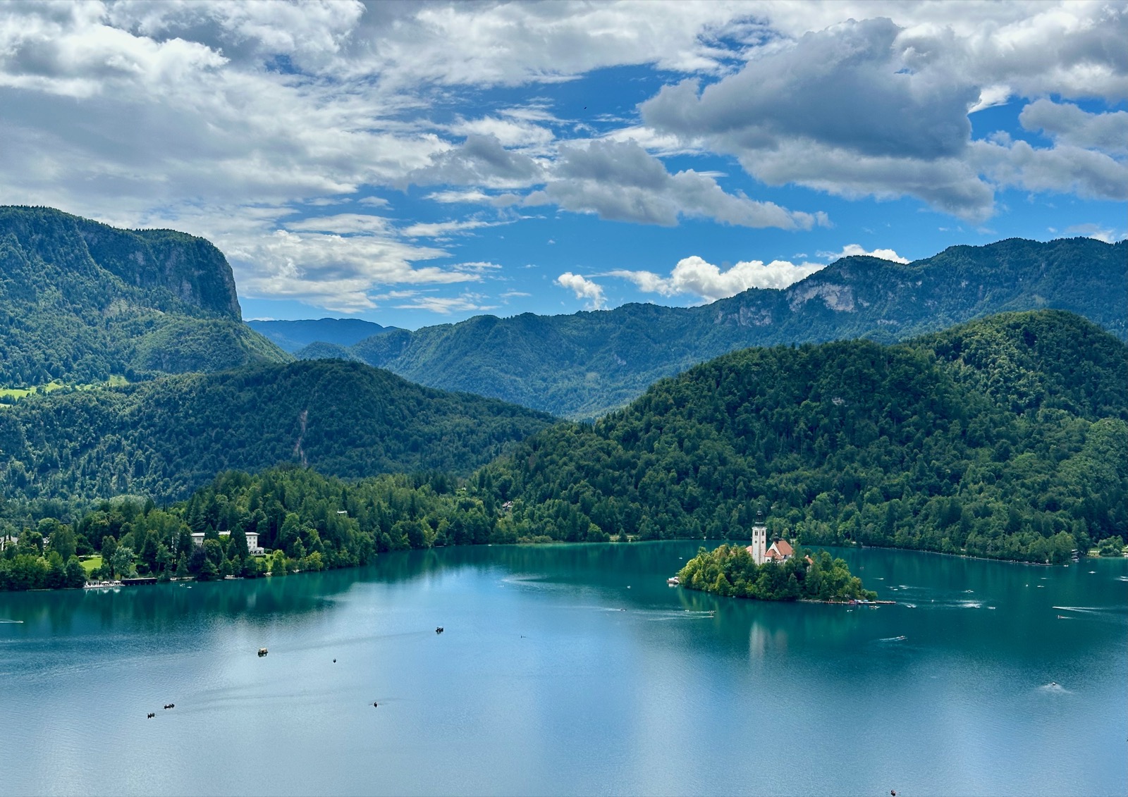 Bled, Slovenia's emerald lake cradles a picturesque island with a charming church, framed by lush, mountainous terrain.