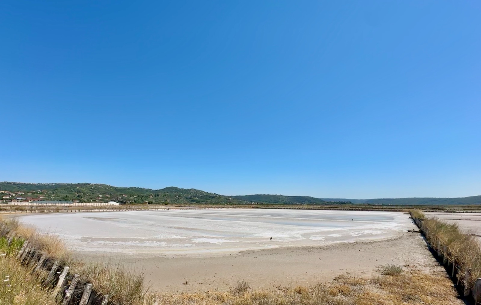 Portoroz's salt pans glisten under Slovenia's clear blue sky, a serene coastal marvel.